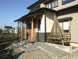 玄関廻りはモルタル塗り仕上げで和風を強調（スロープは歩行用で滑りにくい石で仕上げた）